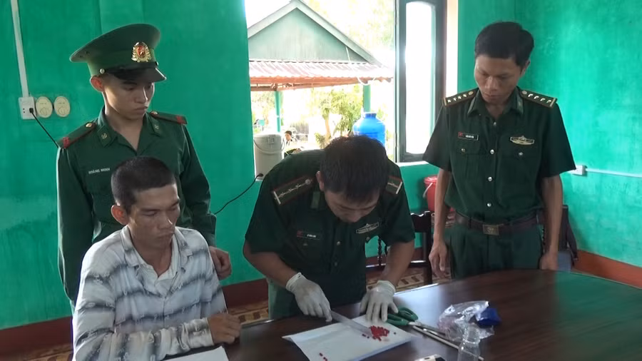 Đối tượng Mai Văn Tới (áo trắng kẻ ngang) bị chiến sĩ Biên phòng bắt giữ.