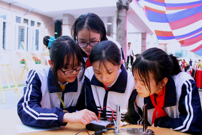 Nhóm học sinh này đang đo dòng của pin mặt trời mà Nhóm Năng lượng vừa tạo ra. Ảnh: Việt Hà