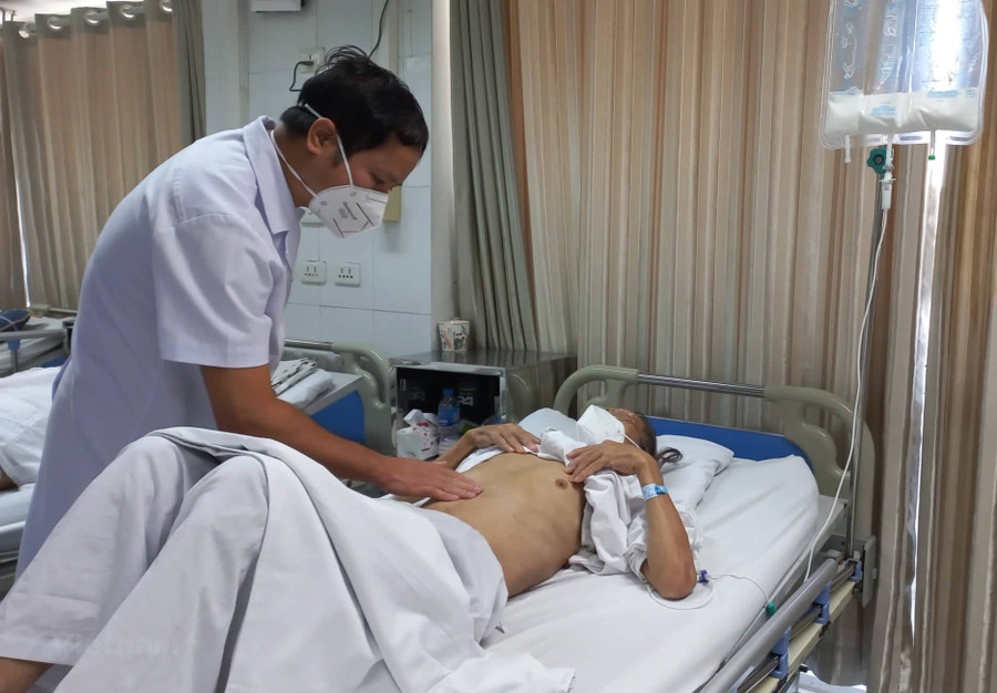 Phó Giáo sư Phạm Hoàng Hà - Trưởng khoa Phẫu thuật tiêu hóa (Bệnh viện Hữu nghị Việt Đức) thăm khám cho một bệnh nhân ung thư dạ dày. Ảnh: INT. Phó Giáo sư Phạm Hoàng Hà - Trưởng khoa Phẫu thuật tiêu hóa (Bệnh viện Hữu nghị Việt Đức) thăm khám cho một bệnh nhân ung thư dạ dày. Ảnh: INT.