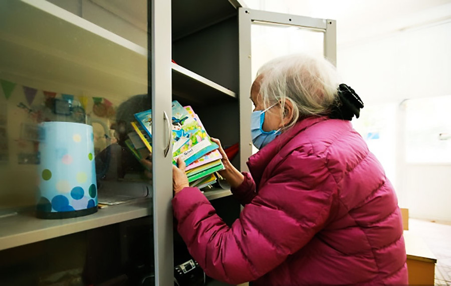 Bà Nam lau dọn, sắp xếp lại sách vở của lớp học tình thương trong thời gian tạm dừng.