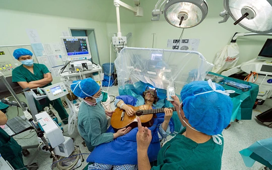 Người đàn ông gảy đàn guitar trên bàn mổ