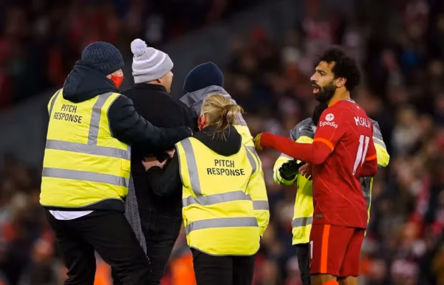 Lực lượng an ninh đưa cổ động viên quá khích tiếp cận Salah ra khỏi sân.