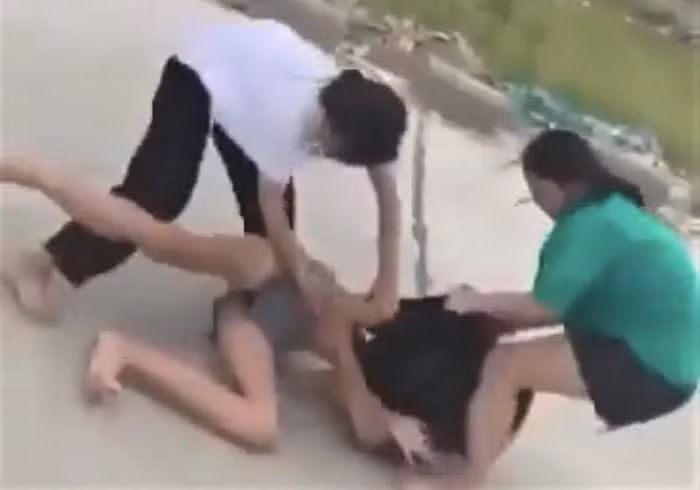 Em Y.N. bị bạn đánh trên bờ đê (Ảnh cắt từ clip).