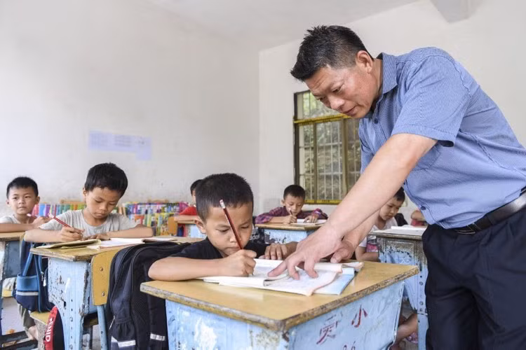 Thầy giáo hướng dẫn học sinh tại một điểm trường ở thị trấn Aidian, khu tự trị dân tộc Choang Quảng Tây, Trung Quốc.