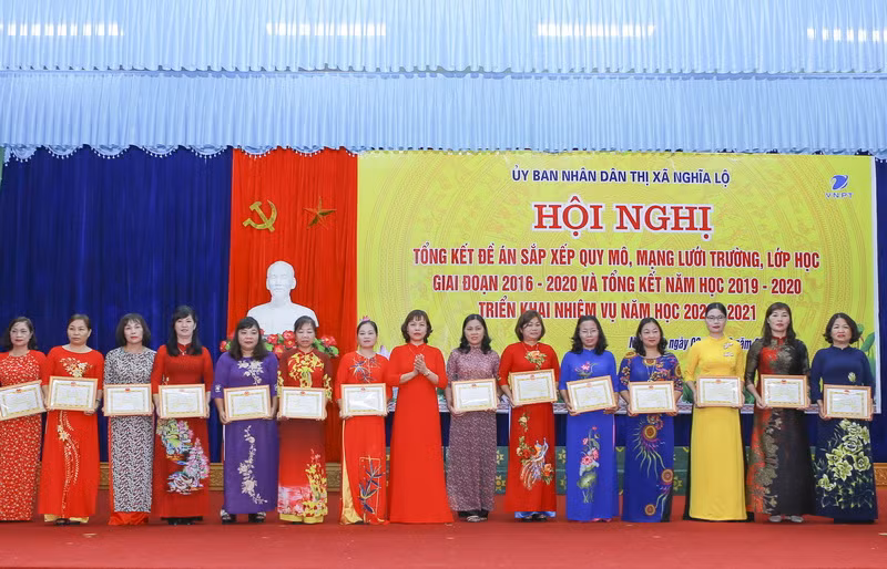 Bà Đỗ Thị Thanh Nga (thứ 8 từ trái qua) trao tặng danh hiệu chiến sỹ thi đua cấp cơ sở cho các nhà giáo tại hội nghị.