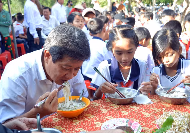 Ông Đoàn Ngọc Hải cùng ngồi ăn thân mật với các em học sinh ở U Minh. Ảnh: Dân trí.