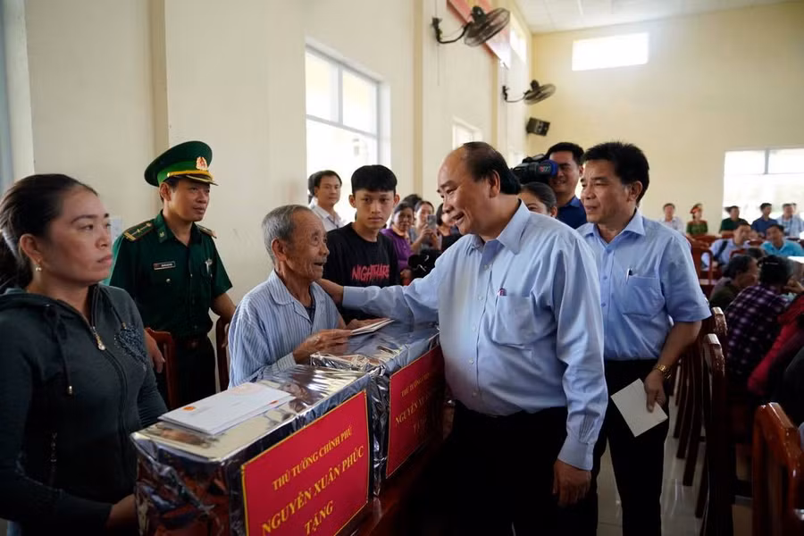 Thủ tướng Nguyễn Xuân Phúc động viên bà con xã Tam Quang, huyện Núi Thành, Quảng Nam đoàn kết, giúp đỡ, hỗ trợ nhau vượt qua khó khăn, sớm trở lại cuộc sống bình thường sau thiên tai. Ảnh VGP/Quang Hiếu.