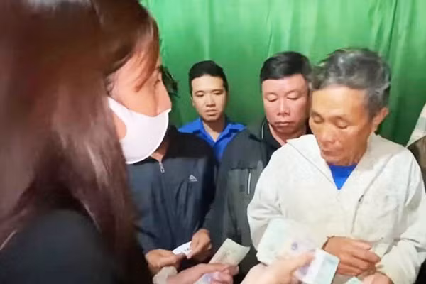 Ông Báu xúc động nhận số tiền hỗ trợ của ca sỹ Thủy Tiên. Ảnh: FB Thủy Tiên.