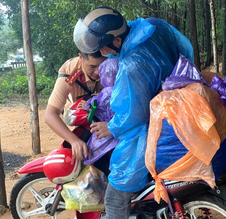 Hỗ trợ áo mưa, xăng xe, bánh và sữa cho bố con anh Khánh tiếp tục hành trình ra quê ở Quảng Bình.