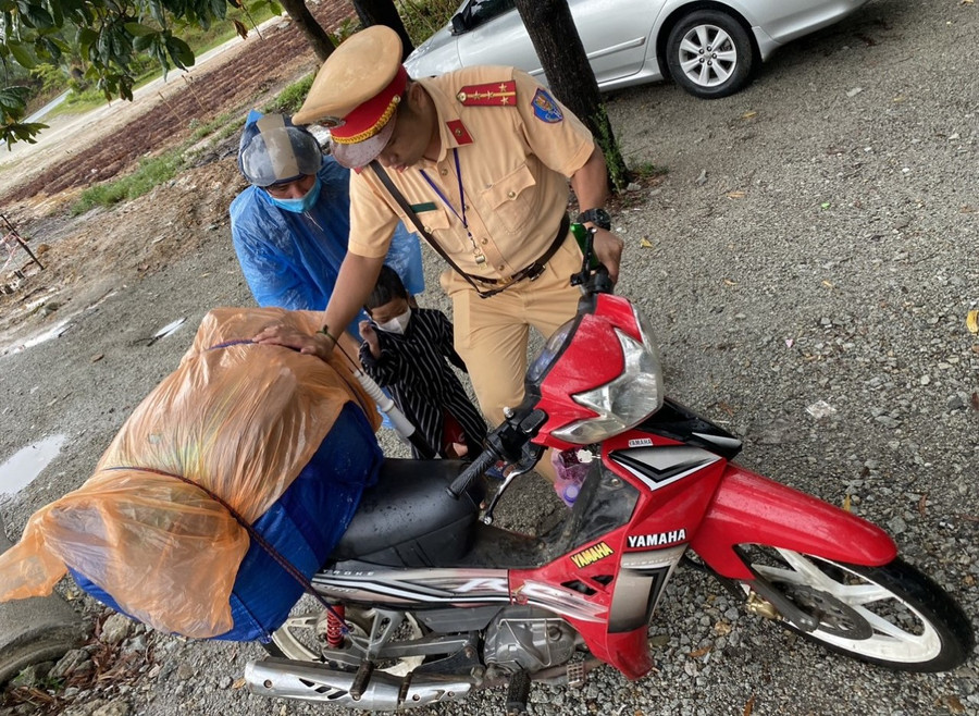 Tổ công tác thuộc Đội CSGT số 1, Phòng CSGT Công an tỉnh Thừa Thiên - Huế giúp đỡ 2 bố con anh Trần Văn Khánh gặp khó khăn do thời tiết mưa lớn.