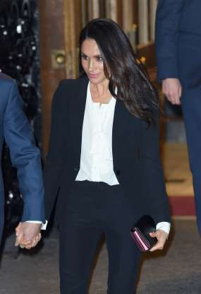 Meghan nổi bật với blazer đen khoác ngoài áo trắng.
