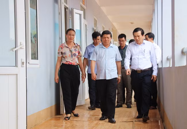 Ông Nguyễn Minh Tường (ngoài cùng bên phải ảnh) kiểm tra cơ sở vật chất, trường lớp học bị thiệt hại do mưa lũ để có phương án khắc phục, chuẩn bị cho năm học mới
