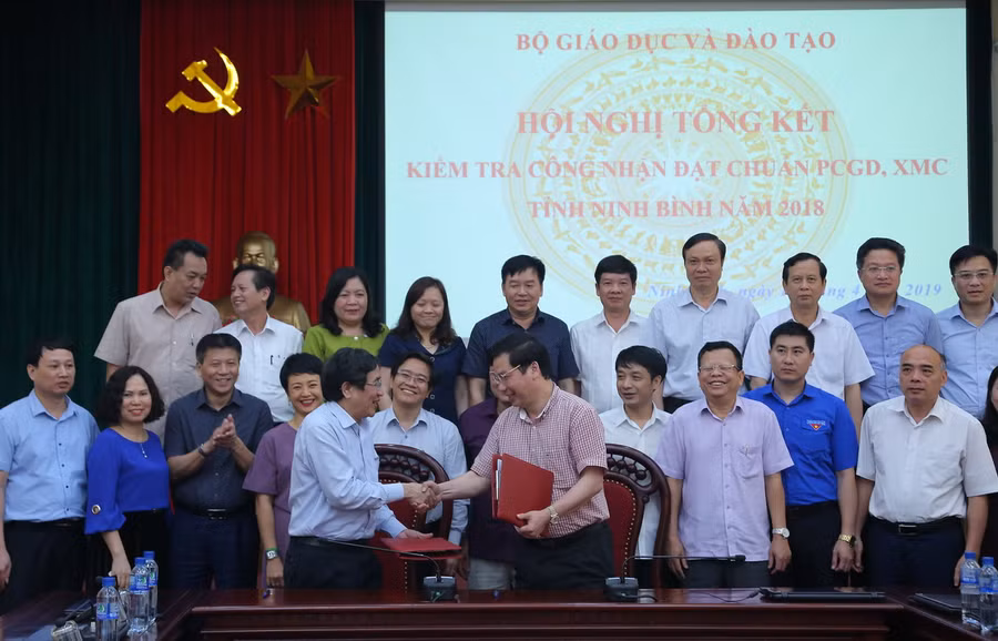 TS Vũ Đình Chuẩn và ông Tống Quang Thìn kí kết biên bản kiểm tra công tác công nhận đạt chuẩn PCGD - XMC. Ảnh Việt Hà