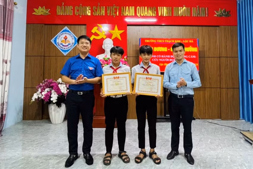 Đại diện Tỉnh đoàn Hà Tĩnh trao thưởng 2 em Phạm Phúc Sinh (lớp 7C) và em Nguyễn Hoàng Phong (lớp 7E, Trường THCS Thạch Kim) vì hành động dũng cảm cứu người. (Ảnh: T.N)