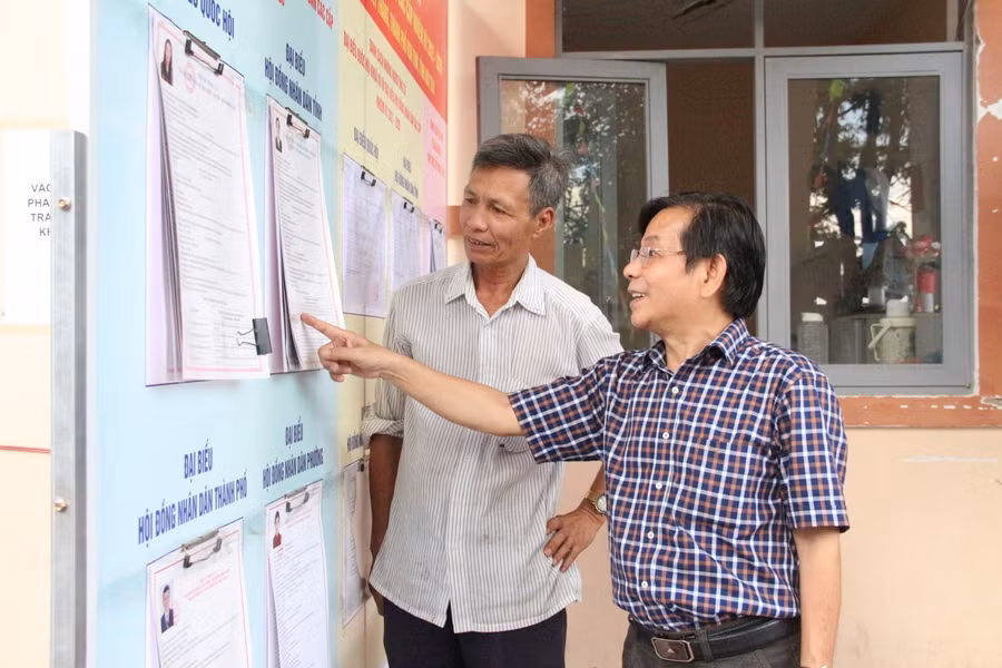 Thầy Trần Ngọc Lâm hướng dẫn cán bộ, giáo viên, nhân viên tìm hiểu thông tin về bầu cử.