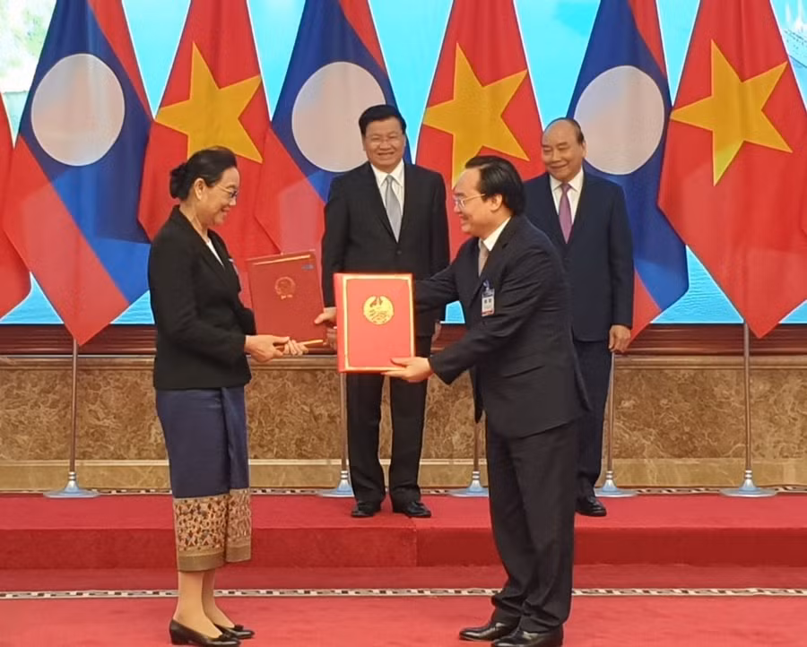 Bộ trưởng Phùng Xuân Nhạ và Bộ trưởng Sengdeuane Lacchanthaboune trao văn bản hợp tác.