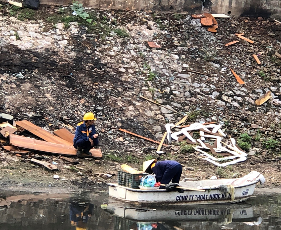 Công nhân môi trường đang đi gom rác thải trên sông Tô Lịch