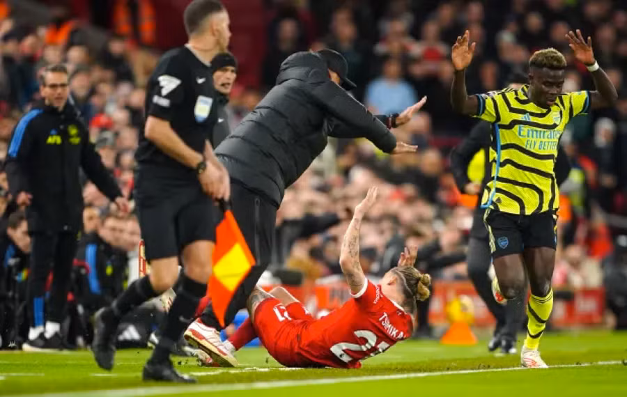 Kostas Tsimikas va chạm với HLV Jurgen Klopp của Liverpool sau tác động của Bukayo Saka bên phía Arsenal. Kostas Tsimikas va chạm với HLV Jurgen Klopp của Liverpool sau tác động của Bukayo Saka bên phía Arsenal.