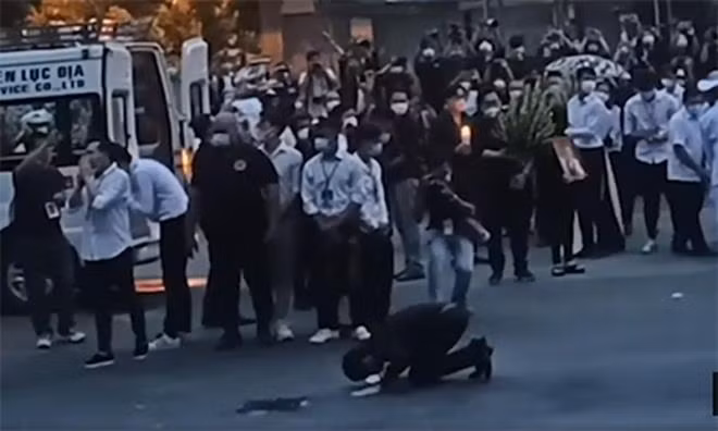 Hoài Linh quỳ xuống chắp tay lạy về phía khán giả khi linh cữu của Chí Tài được đưa đến sân bay hôm 13/12.