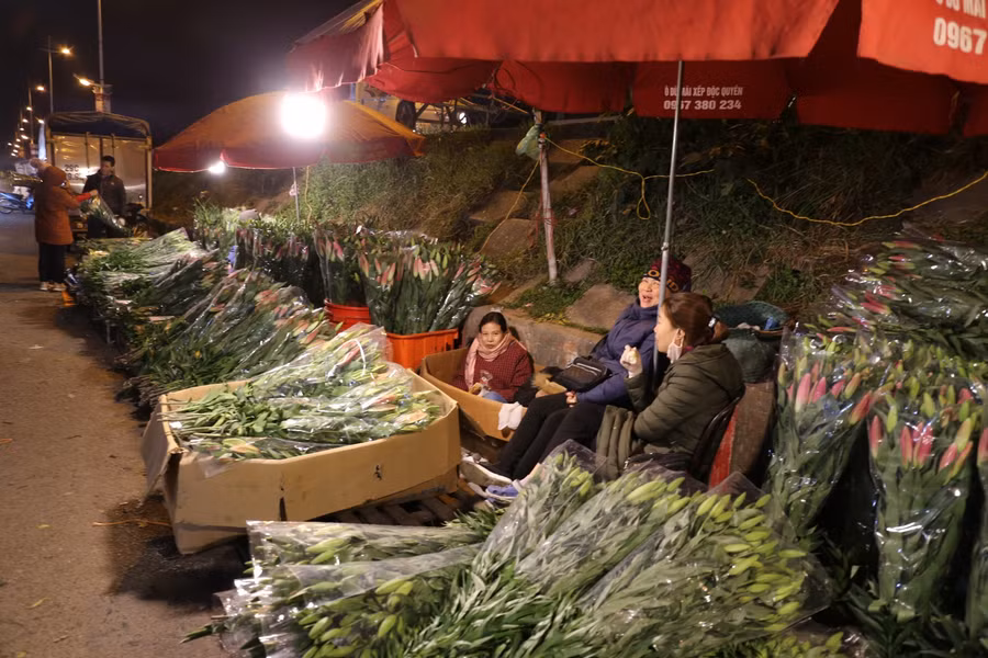 Những phụ nữ bán hoa ỏ chợ hoa Quảng Bá luôn tươi tắn, họ cho biết dù mưa rét nhưng phải bán hết hàng mới nghỉ, có khi tới sáng.
