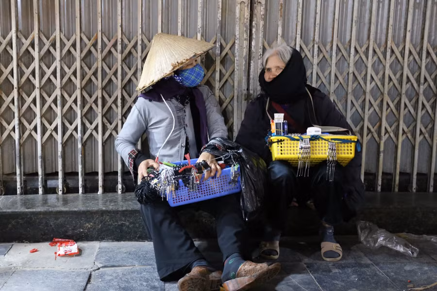 Trên phố Hàng Mã có 2 cụ bà bán hàng tạp hóa rong tranh thủ lúc nghỉ chân hỏi han nhau về tình hình quê nhà. Hai cụ quê tận Thanh Hóa, ra Hà Nội bán thuê, các cụ cho biết thường ngày các cụ bán đến 2 giờ sáng mới về chỗ trọ, trời rét thế này, vắng khách, có khi về sớm hơn.