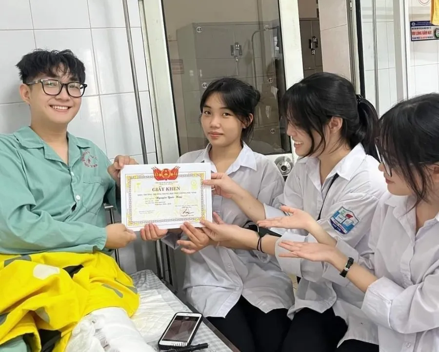 Nguyễn Quốc Huy đón Giấy khen Học sinh giỏi từ các bạn trên giường bệnh.