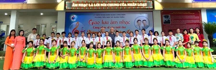 Nhạc sĩ Hoàng Long và Hoàng Lân chụp hình kỷ niệm cùng thầy trò Trường Tiểu học Vũ Xuân Thiều. Ảnh: NTCC