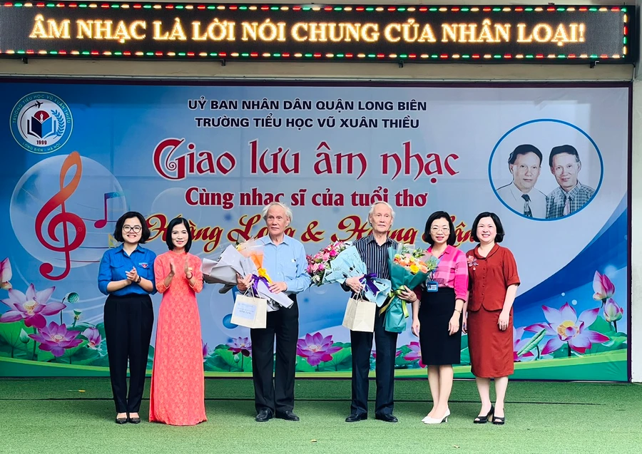 Đại biểu Ban Giám hiệu Trường Tiểu học Vũ Xuân Thiều và lãnh đạo các phòng ban UBND quận Long Biên chúc mừng nhạc sĩ Hoàng Long và Hoàng Lân. Ảnh: NTCC