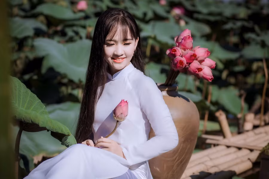 Thần đồng Bolero - Kim Chi với tà áo trắng học trò tinh khôi bên hồ sen. Photo : Hải Color.
​Make: Chu Hiên.