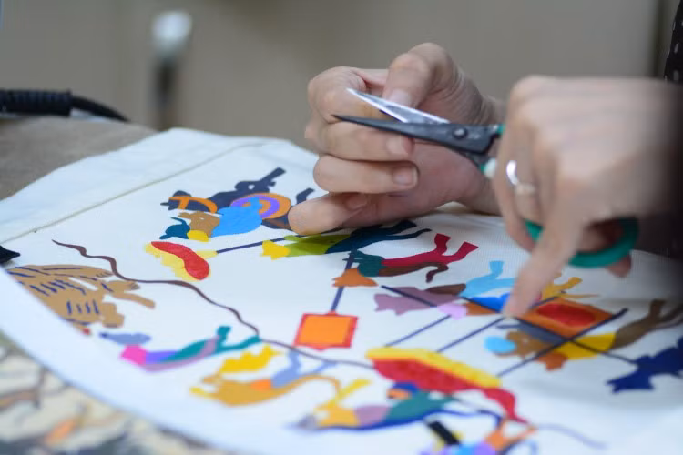 Bàn tay khéo léo của người khuyết tật đã “hô biến” những mảnh vải vụn thành các sản phẩm hoàn thiện như tranh lụa, túi vải…