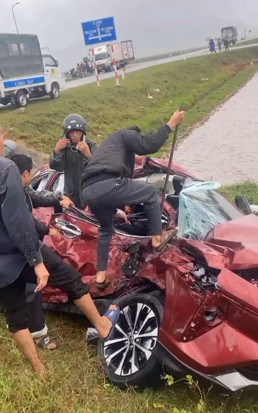 Người dân dùng vật dụng cạy cửa xe để đưa nạn nhân đi cấp cứu. (Ảnh: CTV)