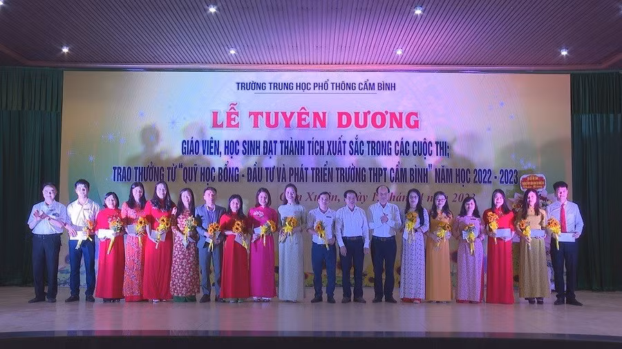 Giáo viên và học sinh Trường THPT Cẩm Bình nhận hoa chúc mừng, giấy khen tại lễ tuyên dương. (Ảnh: Hồ Tứ).