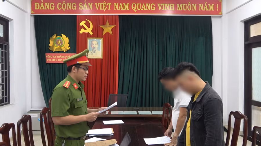 Công an đọc các quyết định khởi tố vụ án, khởi tố bị can đối với N. và L.(Ảnh: Công Quang)