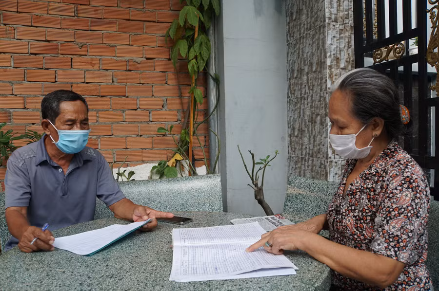 Một cán bộ khu phố ở phường Thạnh Mỹ Lợi, TP Thủ Đức, TPHCM đến từng hộ dân giải quyết thủ tục nhận trợ cấp vì ảnh hưởng của dịch Covid-19, tháng 4/2020. Ảnh: Mạnh Tùng