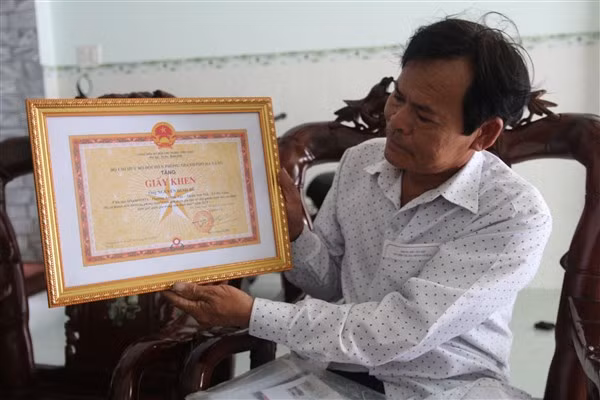 Ngư dân Nguyễn Đình Bê cùng giấy khen về thành tích tốt trong bảo vệ an ninh biên giới quốc gia.