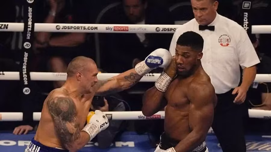 Usyk (trái) tung cú đấm tay trái vào Joshua hôm 26/9.