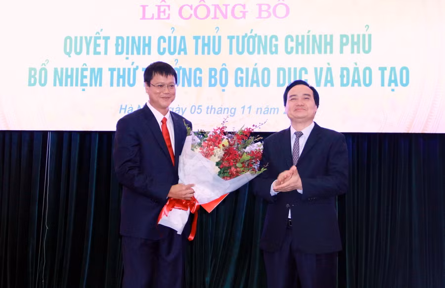 Bộ trưởng Phùng Xuân Nhạ trao quyết định và tặng hoa chúc mừng tân thứ trưởng Lê Hải An.