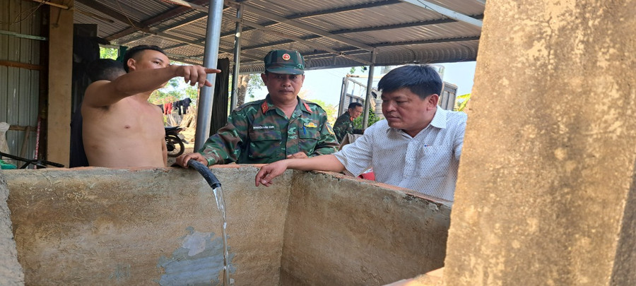 Ông Lê Văn Hoàng Lâm, Chủ tịch UBND xã Ia Rvê (ngoài cùng bên phải) cùng lực lượng Quân đội tiếp nước cho người dân. (Ảnh: Thành Tâm)
