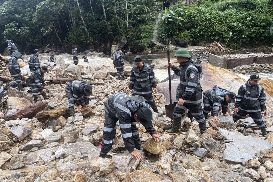 Lực lượng chức năng hỗ trợ người dân khắc phục hậu quả thiên tai.