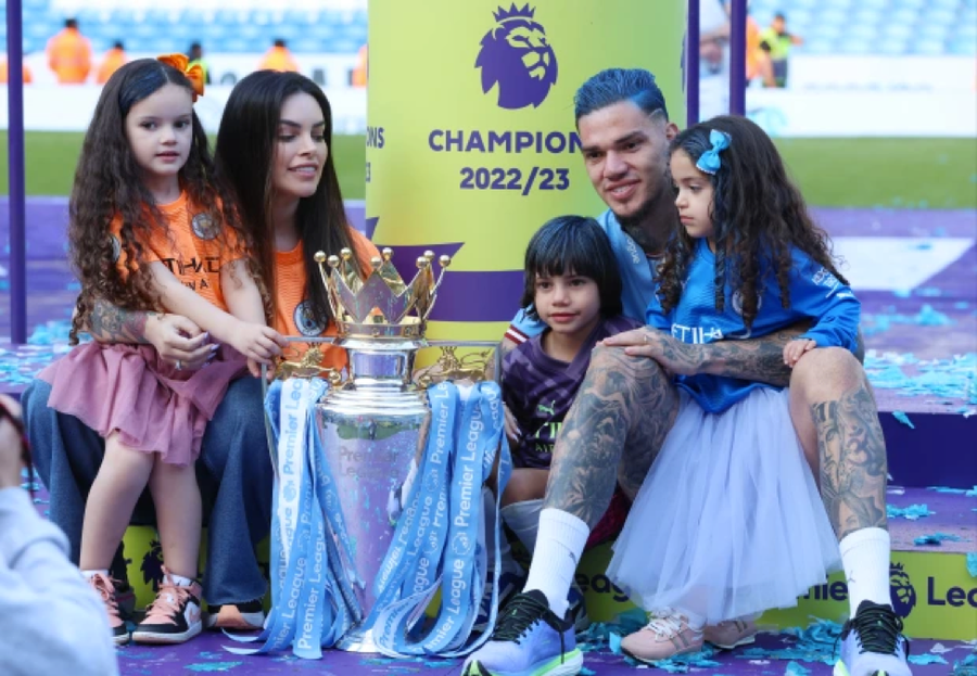 Ederson và vợ con mừng chức vô địch Premier League của Man City. Ederson và vợ con mừng chức vô địch Premier League của Man City.