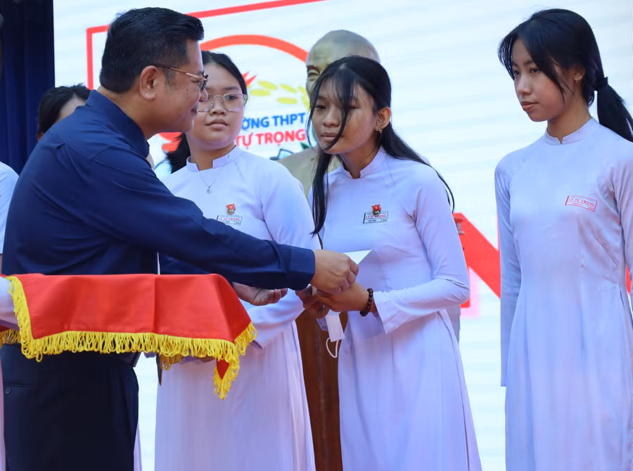 ThS Vũ Đình Lê - Phó Giám đốc phụ trách Trung tâm Tư vấn tuyển sinh Trường ĐH Luật TP HCM trao học bổng cho học sinh nghèo hiếu học