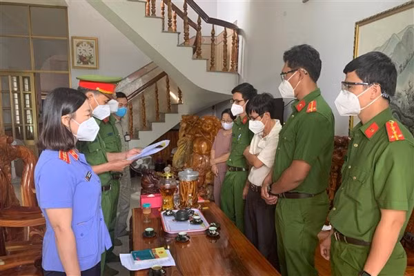 Lực lượng cảnh sát đọc lệnh khởi tố, bắt giam ông Nam (áo sáng màu, thứ 3 từ phải sang).