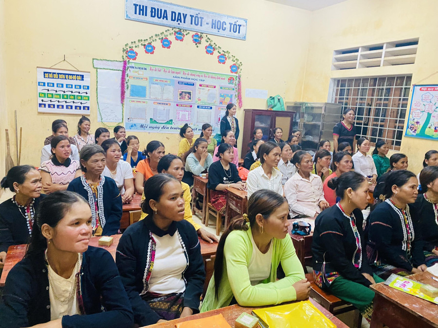 Phụ nữ vùng biên giới chăm chú theo dõi thầy giáo quân hàm xanh và cán bộ phụ nữ hướng dẫn. Ảnh: Văn Hữu