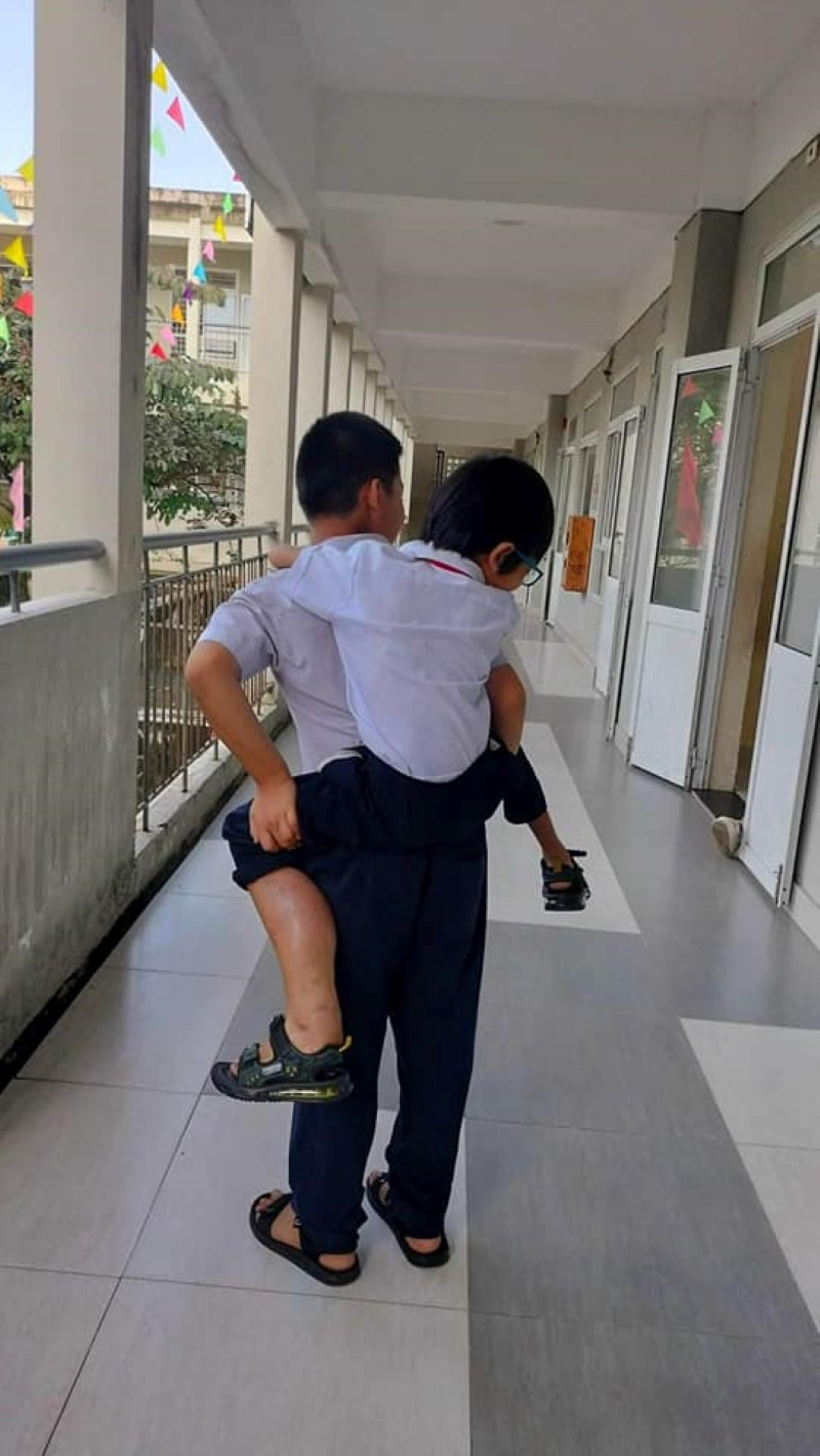 Em K.H.Đ - học sinh Trường THCS Nguyễn Bỉnh Khiêm được bạn cõng đến lớp. Ảnh: NTCC Em K.H.Đ - học sinh Trường THCS Nguyễn Bỉnh Khiêm được bạn cõng đến lớp. Ảnh: NTCC