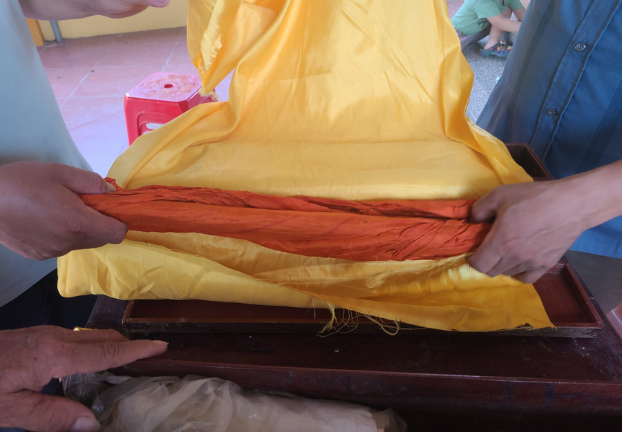 Phía ngoài ống nứa chứa sắc phong được bọc bằng các tấm vải lụa.