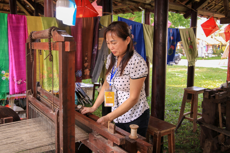 Nghệ nhân dệt của Làng nghề dệt Phùng Xá tại không gian trưng bày. Nghệ nhân dệt của Làng nghề dệt Phùng Xá tại không gian trưng bày.