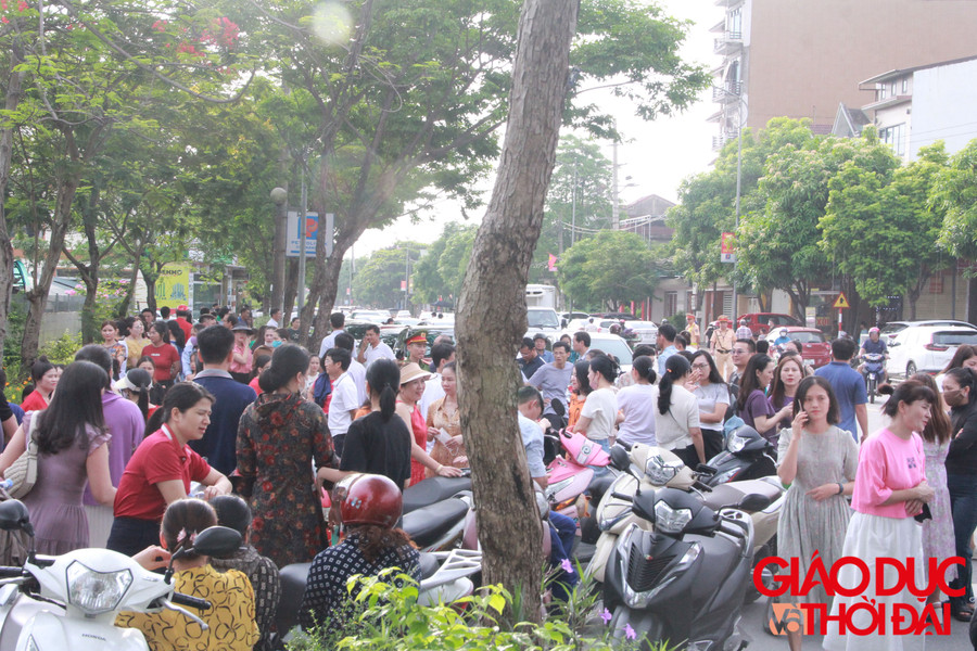 Bên ngoài phòng thi, sức &quot;nóng&quot; không hề kém cạnh khi rất nhiều phụ huynh hồi hộp theo dõi con mình làm bài. (Ảnh: Vũ Long)