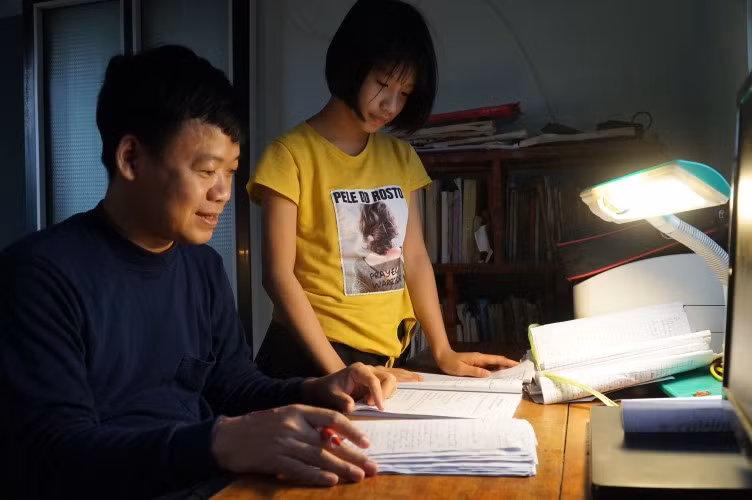 Thầy Ngô Đức Đồng hướng dẫn con gái trả lời bài tập về nhà.