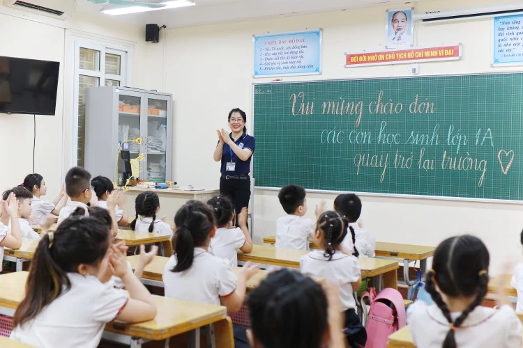 Giáo viên Trường TH Thăng Long vui mừng đón học sinh trở lại trường sau thời gian giãn cách xã hội vì Covid-19. Ảnh: Thế Đại