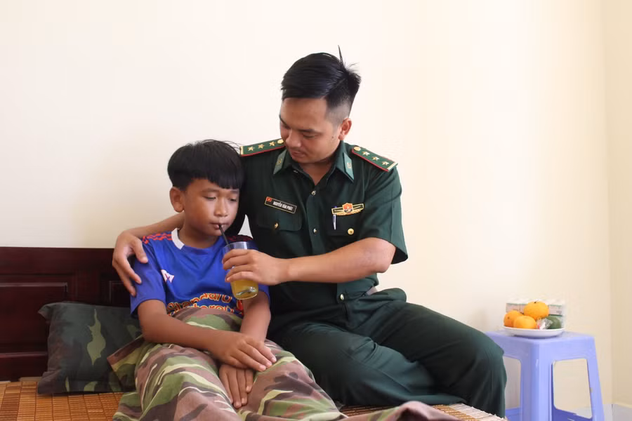 Thượng úy Nguyễn Văn Phát chăm sóc con nuôi Phạm Quốc Sỹ lúc bị ốm.